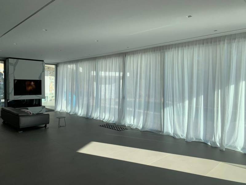 Confection de rideaux voilage pour habillerprès de 12 m de baies vitrées dans la pièce à vivre d'une villa près d'Aix en Provence