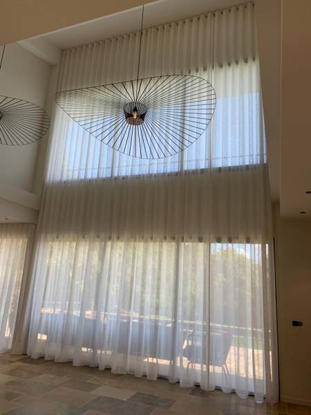 Le rideau wave avec système de tringles électriques pour habiller les grandes baies vitrées dans les espaces contemporains, ici chez un particulier à Cucuron dans le Luberon
